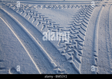 GRAPHIC TYRE TRACKS IN DEEP WINTER SNOW: Tyre tracks in virgin overnight snow from heavy duty vehicles in Finland Stock Photo