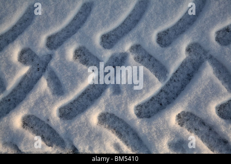 GRAPHIC TYRE TRACKS IN DEEP WINTER SNOW: Tyre tracks detail in virgin overnight snow from heavy duty vehicle in Finland Stock Photo