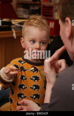 TODDLER WITH MUM FEEDING TIME SPOON CUTE: Two year old toddler child feeds his mother with a teaspoon model released Stock Photo