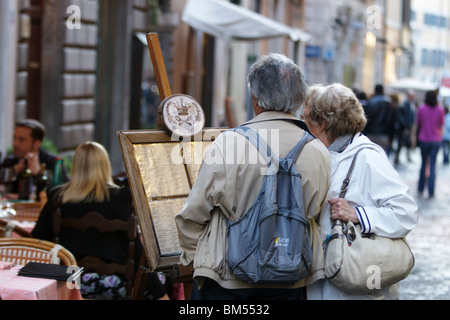 Rome Italy tourists senior couple checking a menu sign in street restaurant Stock Photo