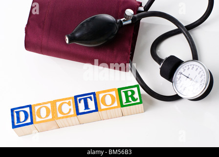Colorful children's blocks spelling DOCTOR with a blood pressure cuff Stock Photo
