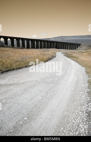A long track to a dark ominous railway viaduct. Stock Photo
