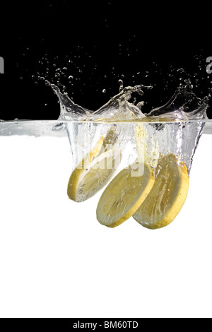 three slices of lemon thrown in water Stock Photo