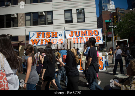 A stand selling fish, wings, and jumbo shrimp at the Ninth Avenue Food Festival in New York Stock Photo