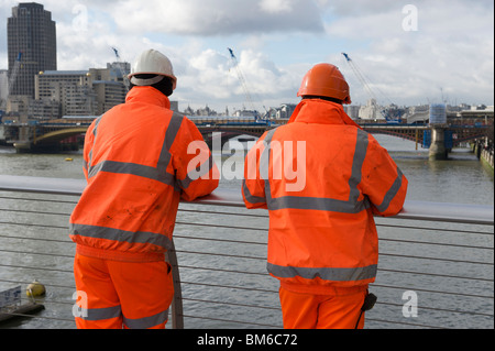 Two workmen in orange high visibility jackets Stock Photo
