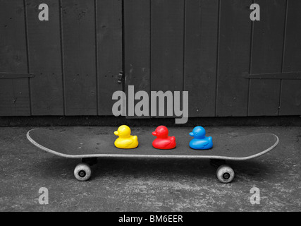 Toy ducks on a skateboard. Stock Photo