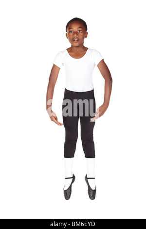 Young African ballet boy on white background and floor showing various ballet steps and positions. Not Isolated Stock Photo