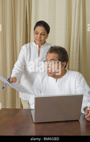 Man looking shocked at a bill held by a woman Stock Photo