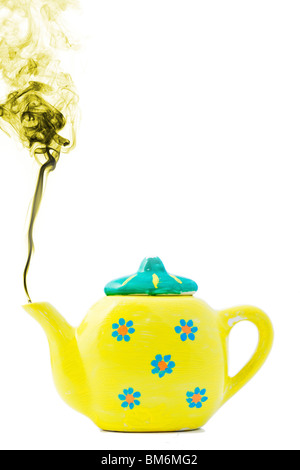 Toy yellow tea pot with steam coming out of spout Stock Photo