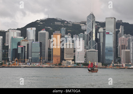 Aqua Luna Tourist Junk, approaching Tsim Sha Tsui, against a backdrop of skyscrapers, from the Central Pier on Hong Kong Island Stock Photo