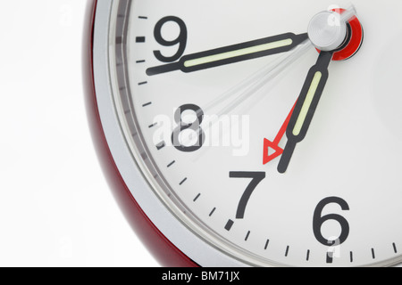 Close up of an alarm clock set to 7 o'clock with luminous hands and second hand moving. Perfect timing concept Stock Photo