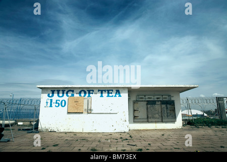 architecture image of a small closed down café building with slogan jug of tea on the front on a sunny day with blue sky Stock Photo