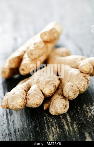 Close up of fresh ginger root spice on wooden table Stock Photo