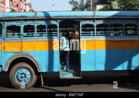 India, West Bengal, Kolkata, A bus conductor stands in the foot well of ...