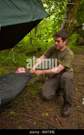 Children being taught bushcraft skills by instructor on course in woodland on Gower Swansea South Wales UK Stock Photo