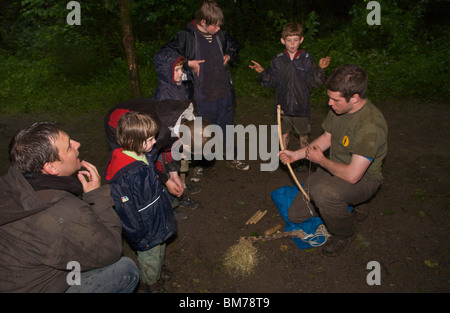 Children being taught bushcraft skills by instructor on course in woodland on Gower Swansea South Wales UK Stock Photo