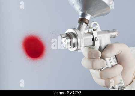 Detail of a hand painting with a paint gun Stock Photo