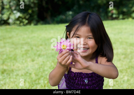 A young girl holding a flower