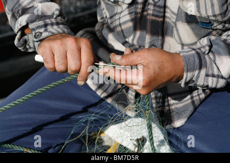 Close up of hand cutting rope with scissors Stock Photo - Alamy