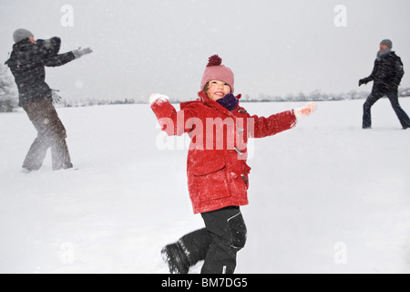 Two parents and their daughters having a snowball fight Stock Photo
