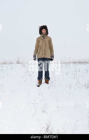 A woman standing on a snowy hill, portrait Stock Photo