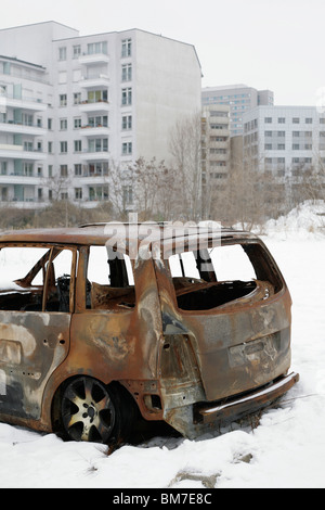 A burned out car abandoned in the snow Stock Photo