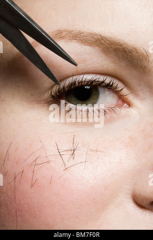 Scissors cutting hair on a woman, detailed shot of eye Stock Photo
