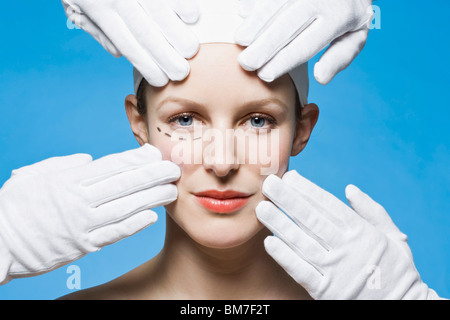 Two healthcare workers, detail of hands, preparing a woman for plastic surgery, headshot Stock Photo
