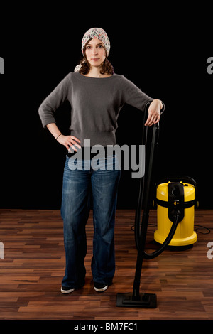 A Woman Standing Next To A Vacuum Cleaner Stock Photo