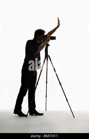 A photographer working with a camera on a tripod Stock Photo