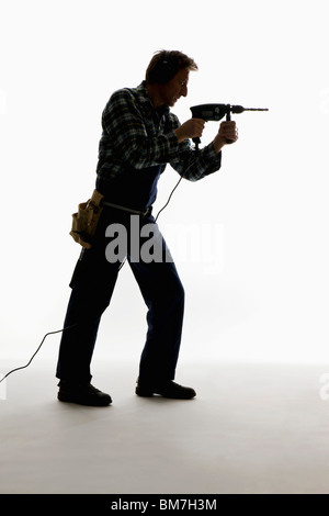 A construction worker using a drill Stock Photo