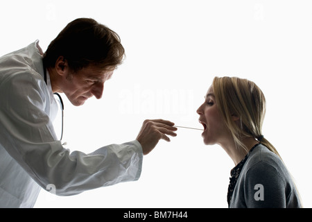 Doctor Using Tongue Depressor Photograph by Science Photo Library