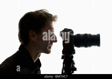 A photographer working with a camera on a tripod Stock Photo