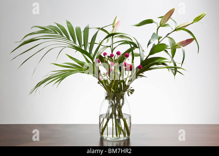 A bunch of Easter lilies and Gomphrena flowers in a vase Stock Photo