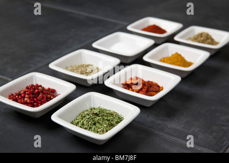 Various herbs and spices in small bowls Stock Photo