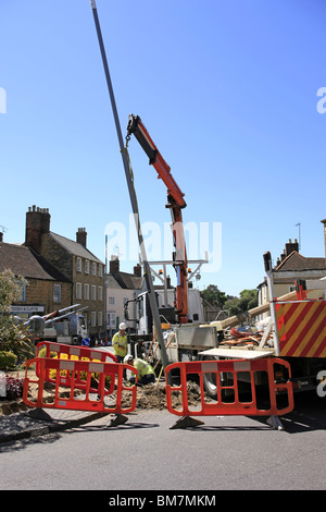 Workmen from the Electricity Company installing new energy efficient street lighting poles in Dorset England Stock Photo