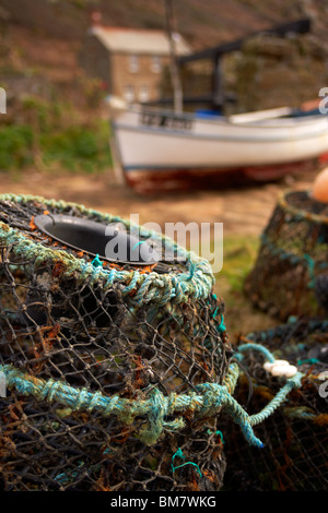 Lobster pots and fishing boats on the cobbled slipway at Penberth Cove Cornwall UK Stock Photo