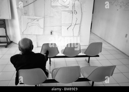 Oscar Niemeyer architect draws his designs on the wall and on paper of his Copacabana studio in Rio de Janeiro, Brazil. Oscar Ribeiro de Almeida Niemeyer Soares Filho (December 15, 1907 December 5, 2012). Niemeyer sits in on of the chairs in his studio; Stock Photo