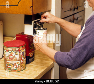 https://l450v.alamy.com/450v/bm89gd/womans-hands-open-can-with-electric-can-opener-food-prepare-cook-kitchen-bm89gd.jpg