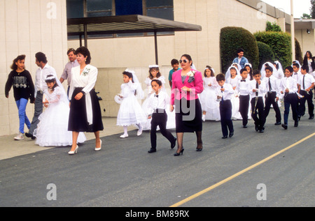 Group of Catholic religious education students are led into church for their first Holy Communion during mass. Stock Photo