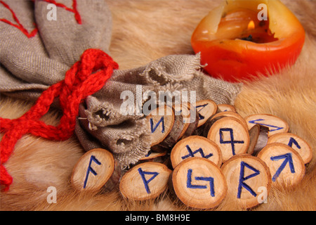 Runes with pouch and candle on the fur Stock Photo