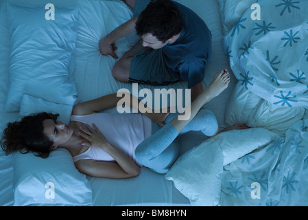Couple having serious conversation in bed Stock Photo