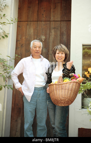 Portrait of senior man and mature woman standing in doorway Stock Photo