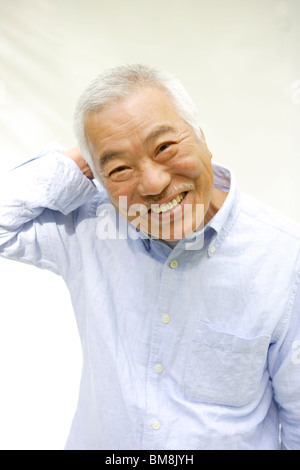 Frontal portrait of a man with his hands behind his back in a dark ...