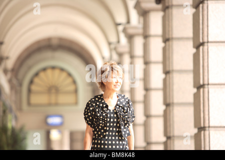 Mature woman in arcade, smiling and looking away Stock Photo