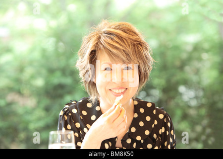 Portrait of mature woman at cafe, smiling, differential focus Stock Photo