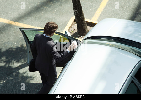 Businessman getting into car Stock Photo