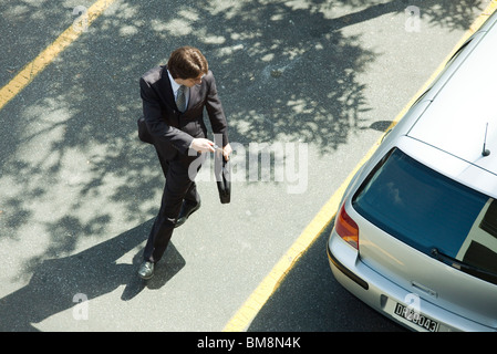 Man locking car doors using key remote as he walks away Stock Photo