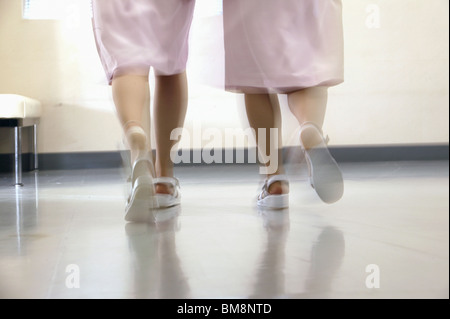Female nurses walking in corridor quickly, blurred motion Stock Photo