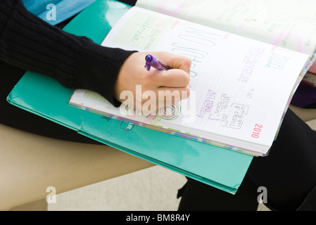 Student writing in notebook Stock Photo